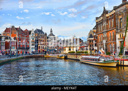 AMSTERDAM, Pays-Bas - 1 janvier 2018 : vue pittoresque du centre-ville d'Amsterdam aux beaux jours après Noël. Des bateaux de tourisme Canal sont amarrées à th Banque D'Images