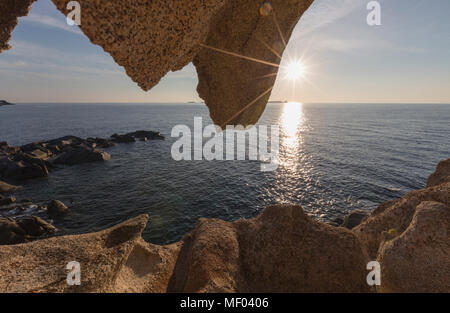 Les rayons se reflètent sur la mer bleue encadrée par une grotte marine naturelle Punta Molentis Villasimius Cagliari Sardaigne Italie Europe Banque D'Images