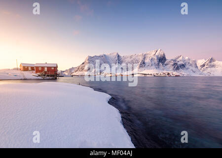 Les couleurs de l'aube les cadres de maisons de pêcheurs entouré par la mer gelée Sakrisøy Reine Nordland îles Lofoten Norvège Europe Banque D'Images