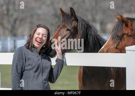 Femme en interaction avec deux beaux chevaux. Banque D'Images