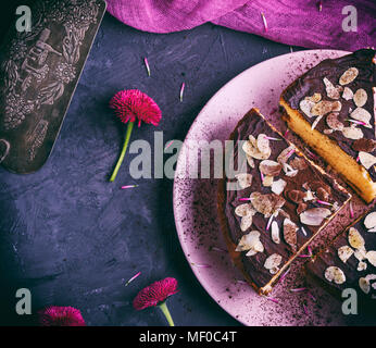 Trois morceaux de gâteau au fromage au chocolat sur une plaque en céramique rose, vue du dessus Banque D'Images