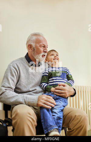 Garçon assis sur les genoux de grand-père dans la salle d'attente Banque D'Images