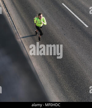 Young woman running on a street Banque D'Images