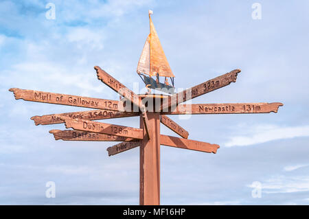 Direction du tourisme et des signes à distance monté sur poster avec girouette en haut, situé sur rivage à Port William, Dumfries & Galloway, Scotland, UK Banque D'Images