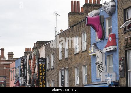 Low angle photographie montrant trois dimensions, annonces de décoration, tels que les chaussures, y compris Nike, New Balance, Van's, tous les Star's, Dr Martens, et Adidas, sur la brique apparente des vitrines d'une rue située à Camden Market à Londres, Royaume-Uni, le 28 octobre 2017. () Banque D'Images