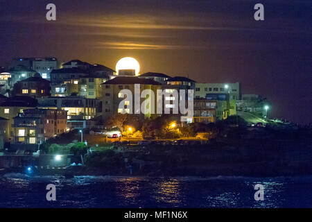 La "super lune", la plus grande pleine lune vu pendant 70 ans, s'élevant au-dessus de la caps de Bondi Beach à Sydney, Australie. La pleine lune n'aura pas l'air Cette grande de nouveau jusqu'à l'année 2034. Banque D'Images