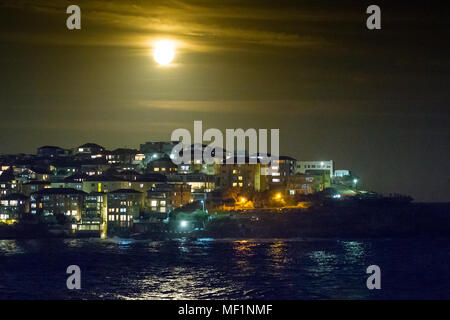 La "super lune", la plus grande pleine lune vu pendant 70 ans, s'élevant au-dessus de la caps de Bondi Beach à Sydney, Australie. La pleine lune n'aura pas l'air Cette grande de nouveau jusqu'à l'année 2034. Banque D'Images