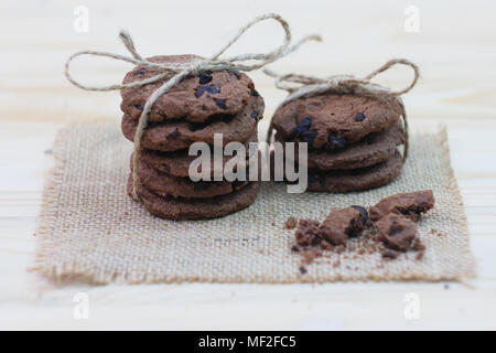 Cookies aux pépites de chocolat sont liées, dans une rangée de don sur une table en bois Banque D'Images