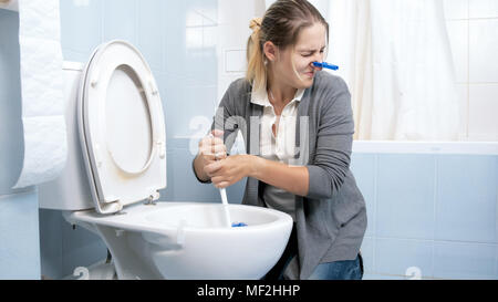 Portrait de jeune femme sentiment de dégoût et de mauvaise odeur toilettes nettoyage à domicile Banque D'Images