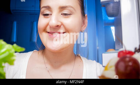 Portrait de jeune femme endormie à la recherche de quelque chose à manger dans le réfrigérateur Banque D'Images