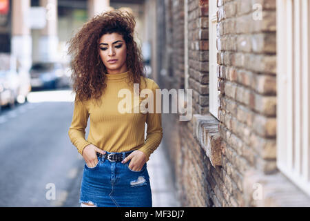 Espagne, Andalousie, Grenade. Jeune femme sérieuse avec curly hairstyle extérieur. Concept de vie Banque D'Images