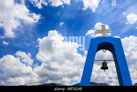 Clocher de l'église en Grèce. Croix en haut et Bell en vertu de celui-ci. Les nuages blancs sur fond bleu ciel de montagne, copyspace Banque D'Images