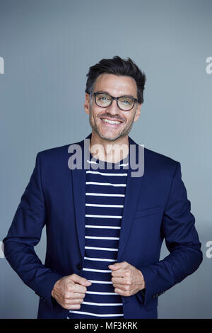 Portrait of Laughing Man avec le port de lunettes et manteau costume bleu Banque D'Images