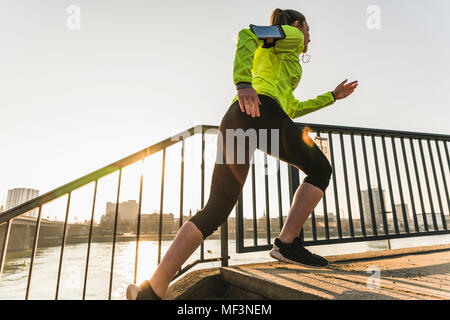 Jeune femme en marche vers le haut des escaliers à une rivière Banque D'Images