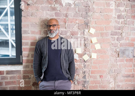 Portrait de freelancer leaning against wall dans un loft Banque D'Images