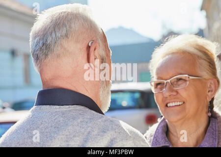 Close-up of senior man with hearing aid parler à senior woman Banque D'Images