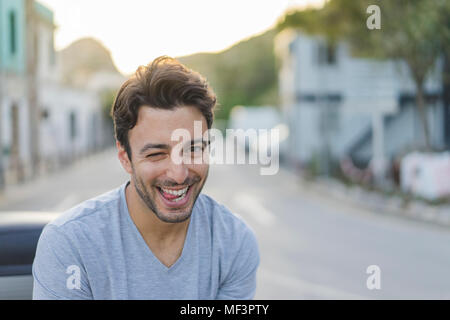 Portrait of laughing young man pulling funny faces Banque D'Images