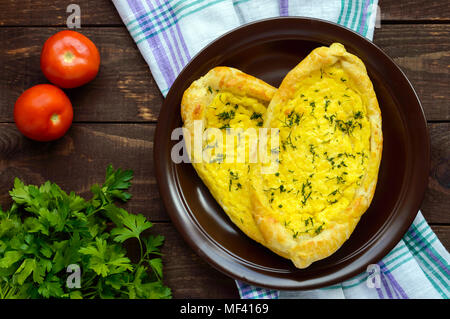 Khachapuri à Adjara (des galettes avec différents matériaux sous la forme d'un bateau) - le plat national de la cuisine géorgienne. La vue de dessus Banque D'Images