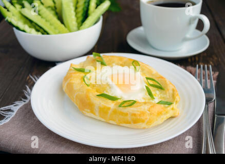 Khachapuri à Adjara (des galettes avec différents matériaux sous la forme d'un bateau) - le plat national de la cuisine géorgienne. Et une tasse de thé Banque D'Images