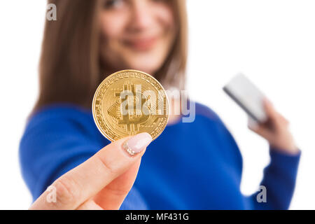 Jeune femme tenant bitcoin gold et carte de crédit comme cryptocurrency et investissement concept paiement virtuel isolé sur fond blanc Banque D'Images