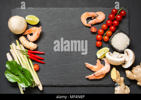 Ensemble spécial pour populaires Thai soupe épicée tom yum kung-lime, galanga, piment, tomate cerise, de la citronnelle et des feuilles de lime kaffir sur ardoise noire lave wit Banque D'Images