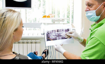 Young blonde woman looking at x-ray image de son teth dans bureau de dentiste Banque D'Images