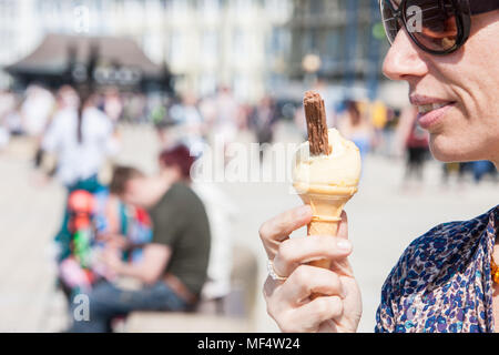 Manger,ice cream,avec,flake,sur,unseasonally,accueil chaleureux,avril,l'été les températures,promenade,Aberystwyth,ensoleillé,bleu,ciel,,samedi,Ceredigion, pays de Galles, Gallois, Banque D'Images