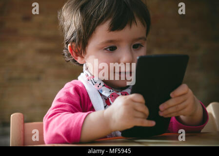 Baby Girl using mobile phone at home Banque D'Images