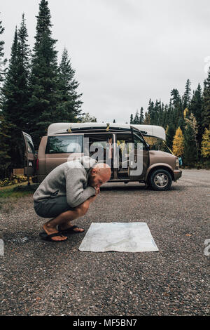 Le Canada, la Colombie-Britannique, l'homme avec une fourgonnette reading map sur l'autoroute Banque D'Images