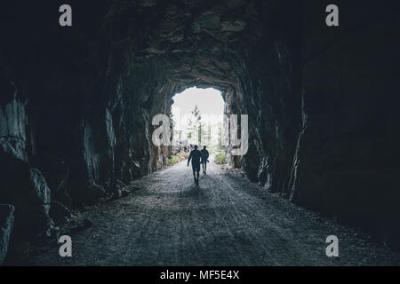 Le Canada, la Colombie-Britannique, Kelowna, Myra Canyon, les randonneurs sur Électrique Valley Rail Trail traversant un tunnel Banque D'Images