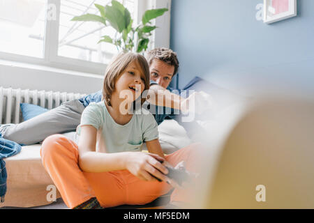 Père et fils jouant ensemble à la maison de jeux vidéo Banque D'Images