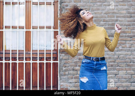 Espagne, Andalousie, Grenade. Belle jeune femme aux cheveux bouclés coiffure déménagement à l'extérieur. Concept de vie Banque D'Images