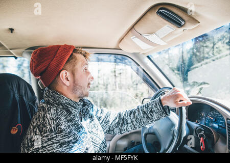 Jeune homme avec barbe et chapeau laineux on a road trip Banque D'Images