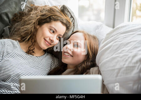 Portrait of two teenage girls relaxing with tablet Banque D'Images