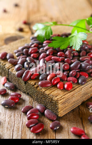 Haricots verts crus rouge avec sur une table en bois Banque D'Images