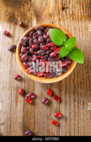 Haricots verts crus rouge avec sur une table en bois Banque D'Images