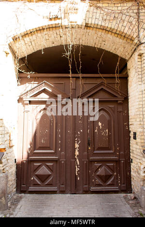 Portes avec old red paint déchiré avec un arc sur le dessus. Banque D'Images
