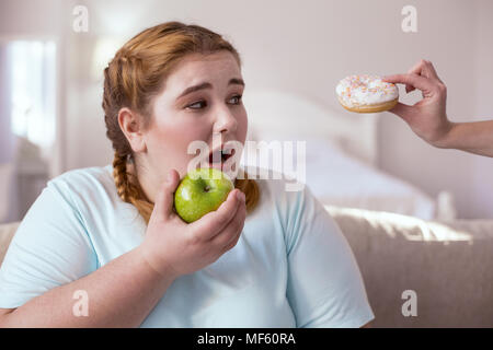 Chubby young woman holding green apple Banque D'Images