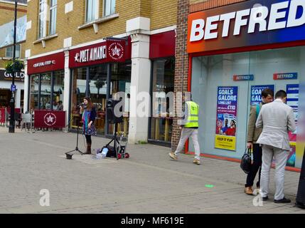 Jeune fille chanter dans Staines High Street Surrey UK Banque D'Images