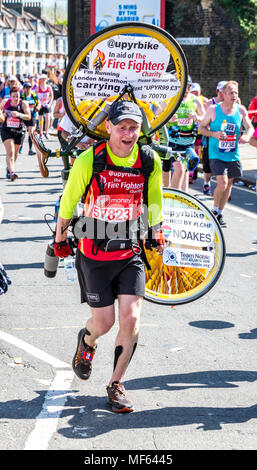 Homme portant un vélo sur le dos sur le marathon de Londres Virgin Money 2018 Banque D'Images