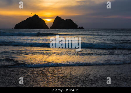 Un spectaculaire coucher de soleil sur l'emblématique charretiers des roches en Baie de Holywell à Cornwall. Banque D'Images