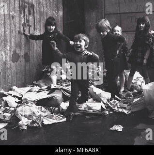 1972, photo historique montrant les enfants debout ensemble sur un tas de déchets ménagers à l'extérieur où ils vivent et jouent dans le sud de Londres. Le jeune garçon est particulièrement stressé et malheureux. Dans les années 1970, un travailleur du secteur public, les grèves sont une caractéristique commune de la vie et refuser était l'une des choses qui ne sont pas recueillies pour les semaines menant à de graves problèmes de santé publique et de l'environnement et pour les enfants danger lorsqu'ils jouent à l'extérieur. Banque D'Images