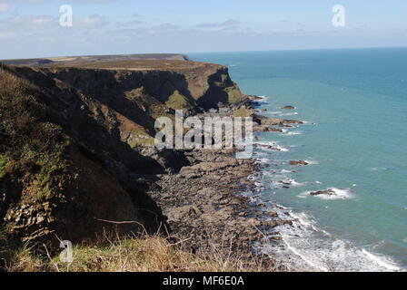 Vue sur une falaise près de la bouche de l'enfer au soleil, avec une mer turquoise, les vagues se brisant sur les rochers au-dessous. Banque D'Images