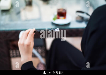 Femme musulmane de fumer le narguilé dans un bar close up Banque D'Images