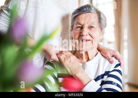 Une vieille grand-mère avec un adulte, petite-fille à la maison. Banque D'Images