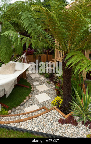 Palmiers exotiques, gazebo, hamac, chemin & fleurs dans le jardin de style tropical show - Visite de plantation : Chic Colonial et Bajan Roots. RHS Show Tatton Park. Banque D'Images