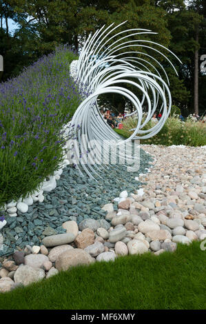 Une sculpture de métal, pierres & cailloux blancs représentent des vagues se brisant sur la rive en 'Wave Dance' garden - RHS Flower Show, Tatton Park, Angleterre, RU Banque D'Images