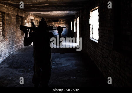 Silhouette d'un soldat avec des armes dans une guerre en ruine Banque D'Images