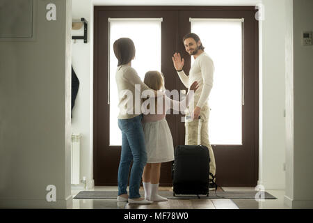 Smiling père salué l'épouse et la fille de quitter la maison Banque D'Images