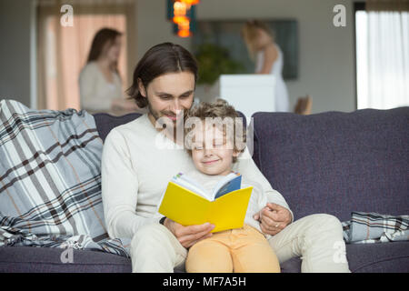 Heureux père et petit fils lecture livre ensemble à la maison Banque D'Images